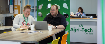 Two people chatting in a brightly coloured office